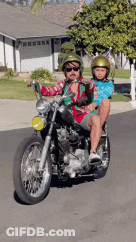 A Man Is Riding A Motorcycle With A Child On His Back GIF