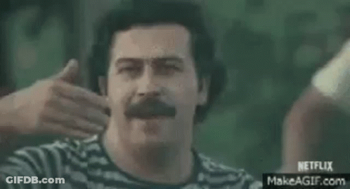 A Man Is Riding A Motorcycle With A Group Of People Behind Him And A Sign That Says `` Venga '' . GIF