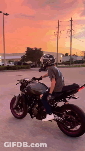 A Man Is Riding A Motorcycle With A Helmet On GIF