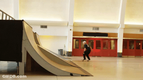 A Man Is Riding A Skateboard Down A Ramp GIF
