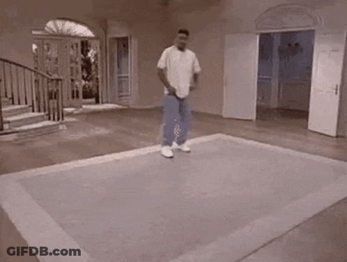 A Man Is Riding A Skateboard On A Rug In A Room . GIF