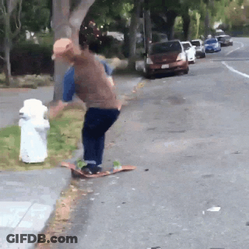 A Man Is Riding A Skateboard On The Side Of The Road GIF