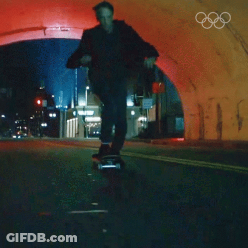 A Man Is Riding A Skateboard Through A Tunnel With The Olympic Rings On The Bottom GIF