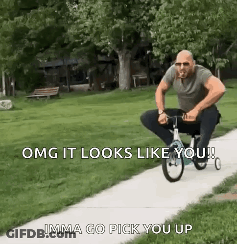 A Man Is Riding A Small Bicycle Down A Sidewalk . GIF