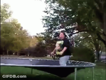 A Man Is Riding A Trampoline With A Dog In His Arms GIF