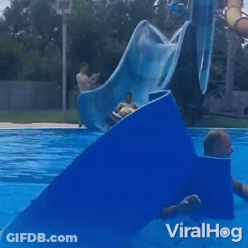 A Man Is Riding A Tube Down A Water Slide At A Water Park With The Words Viralhog On The Bottom GIF