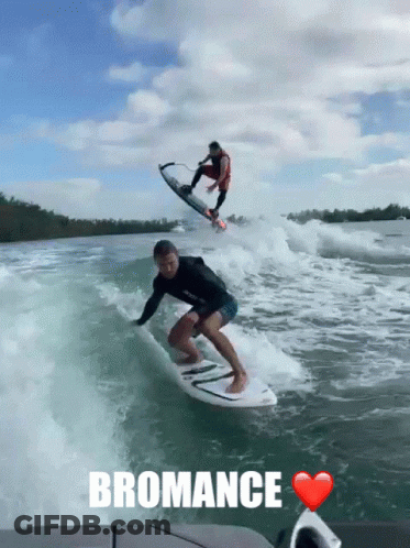 A Man Is Riding A Wave On A Surfboard With The Word Bromance Written Below Him GIF