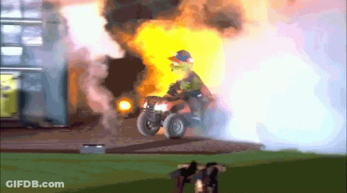 A Man Is Riding An Atv In Front Of A Building That Is On Fire GIF