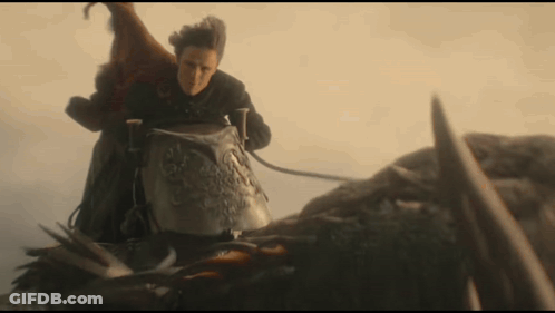 A Man Is Riding On The Back Of A Dragon With A Sword . GIF