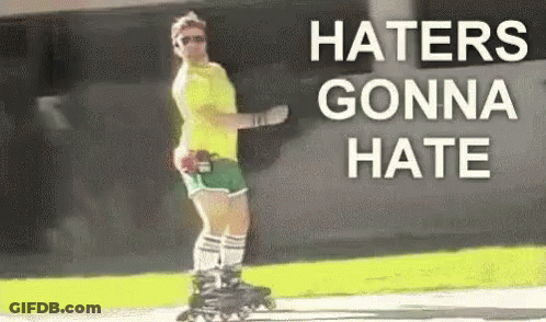 A Man Is Rollerblading Down A Sidewalk With The Words `` Haters Gonna Hate '' Written On The Side . GIF