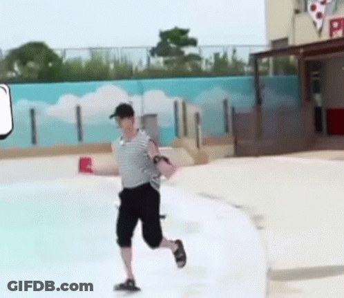 A Man Is Running Across A Swimming Pool While Holding A Red Cup . GIF