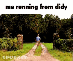 A Man Is Running Down A Dirt Road In A Field . GIF
