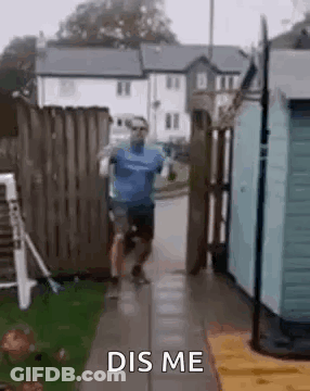 A Man Is Running Down A Sidewalk Next To A Fence . GIF