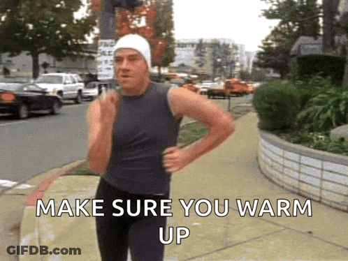 A Man Is Running Down A Sidewalk With The Words Make Sure You Warm Up Behind Him GIF