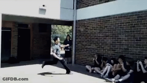 A Man Is Running In Front Of A Group Of People GIF