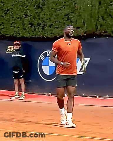 A Man Is Running On A Tennis Court In Front Of A Bmw Sign GIF