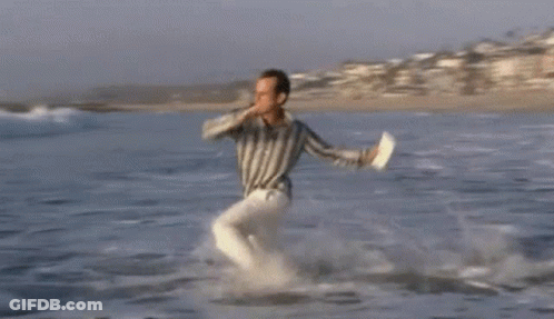 Man Running Out Of Ocean With Flying Kite GIF