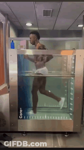 A Man Is Running Through A Machine That Says Core On It GIF