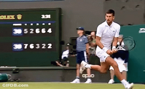 A Man Is Running With A Tennis Racket On A Tennis Court GIF