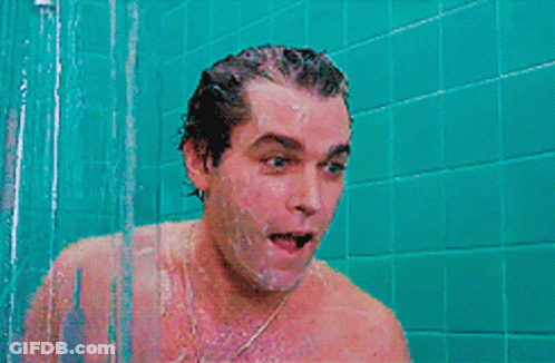 A Man Is Screaming In A Shower With A Blue Tiled Wall Behind Him GIF