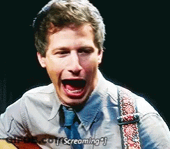 A Man Is Screaming While Holding A Guitar And Wearing A Tie . GIF