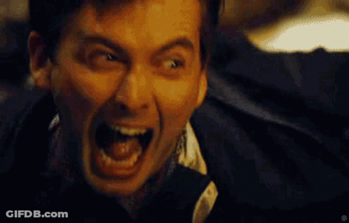 A Man Is Screaming With His Mouth Wide Open GIF