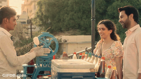 A Man Is Selling Ice Cream To A Woman GIF