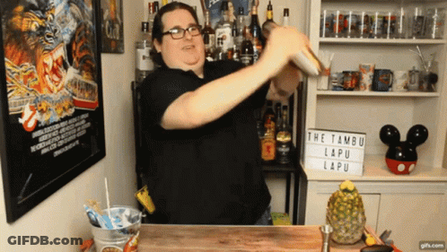 A Man Is Shaking A Drink In Front Of A Sign That Says " The Tambur Lapu " GIF