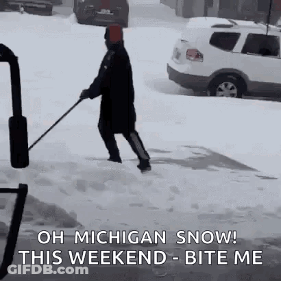A Man Is Shoveling Snow On A Sidewalk With A Sledge . GIF