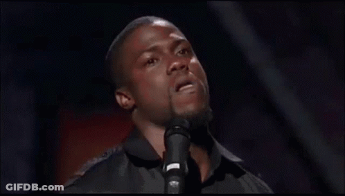 A Man Is Singing Into A Microphone And Making A Face . GIF