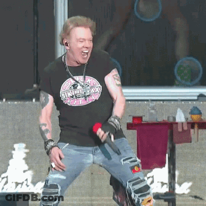 A Man Is Singing Into A Microphone And Wearing A Shirt That Says Skinny Lax GIF