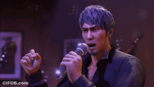 A Man Is Singing Into A Microphone In A Dark Room GIF