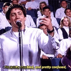 A Man Is Singing Into A Microphone In Front Of A Crowd And Says I 'M Pretty Troubled GIF