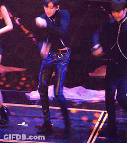 A Man Is Singing Into A Microphone While A Woman Stands Behind Him GIF