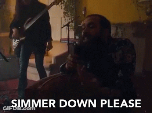 A Man Is Singing Into A Microphone While Another Man Plays A Guitar Behind Him . GIF