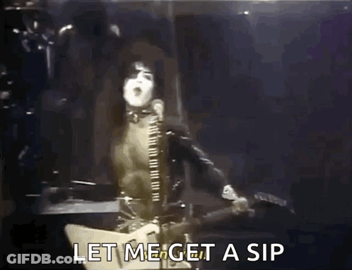 A Man Is Singing Into A Microphone While Playing A Guitar And Says Let Me Get A Sip GIF