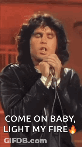 A Man Is Singing Into A Microphone While Wearing A Leather Jacket . GIF