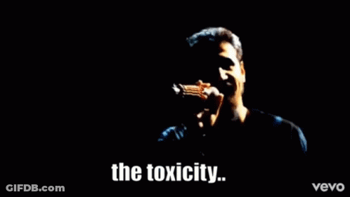 A Man Is Singing Into A Microphone With The Words The Toxicity Written Below Him GIF