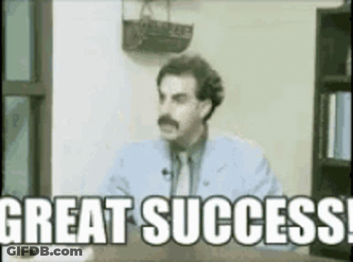 A Man Is Sitting At A Desk And Says Great Success GIF