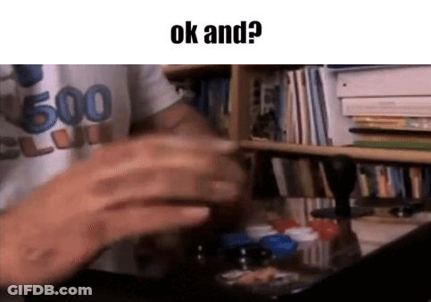 A Man Is Sitting At A Desk In Front Of A Bookshelf With The Words Ok And Written On The Bottom . GIF