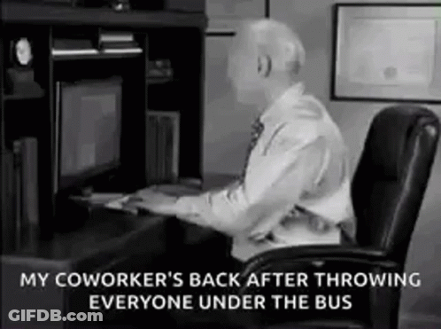 A Man Is Sitting At A Desk In Front Of A Computer And Throwing Someone Under The Bus . GIF