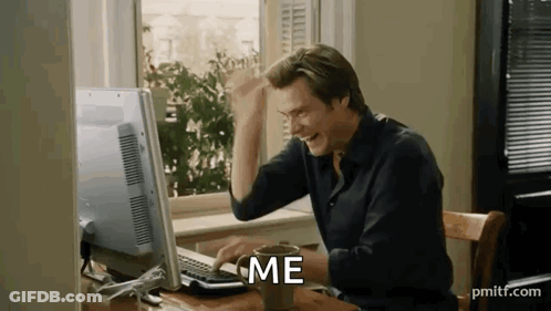 A Man Is Sitting At A Desk In Front Of A Computer With A Cup Of Coffee . GIF