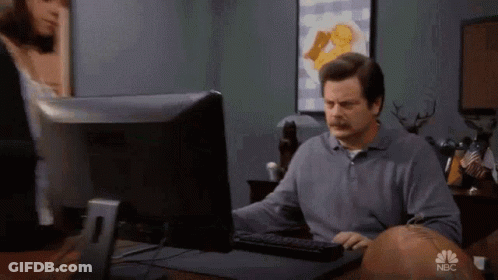 A Man Is Sitting At A Desk In Front Of A Computer With Nbc Written On The Screen GIF