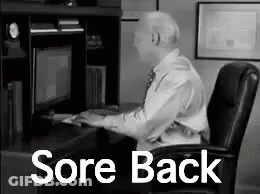 A Man Is Sitting At A Desk In Front Of A Computer With The Words `` Sore Back '' Written On It . GIF