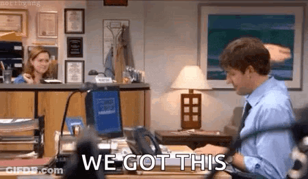 A Man Is Sitting At A Desk In Front Of A Computer With The Words `` We Got This '' Written On The Screen . GIF