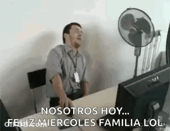 A Man Is Sitting At A Desk In Front Of A Computer Yawning . GIF