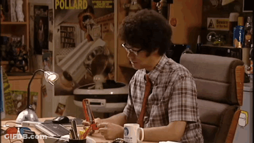 A Man Is Sitting At A Desk In Front Of A Poster That Says Pollard On It GIF