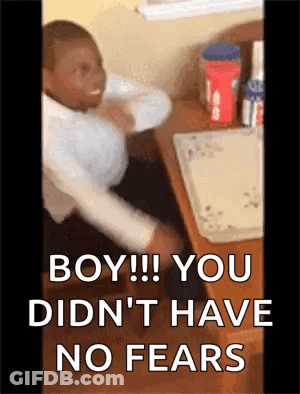 A Man Is Sitting At A Desk With A Box Of Peanut Butter On It . GIF