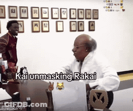A Man Is Sitting At A Desk With A Laptop And The Words Kai Unmasking Rakai Written On The Screen GIF