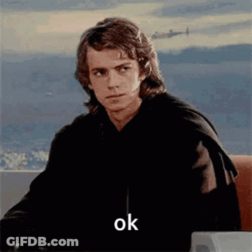 A Man Is Sitting At A Desk With A Plane In The Background And The Word Ok On The Screen . GIF